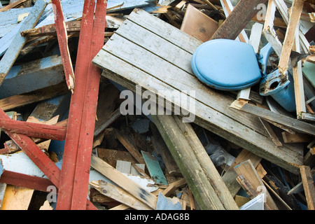 A blue toilet seat on a colorful woodpile at a recycling center Stock Photo