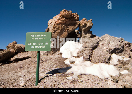 Warning sign Do not stray off footpath in English and Spanish near the summit of Mount Teide Tenerife Canary Islands Spain Stock Photo