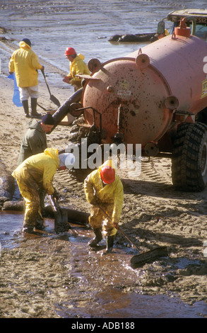 Cleaning oil from polluted beach after Sea Empress disaster Pembrokeshire Wales UK Stock Photo