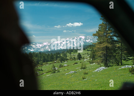 Silhouette of a Man Driving Through Mountainous Terrain Whilst Talking on a Mobile Cell Phone Stock Photo