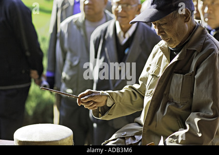 CHINA BEIJING Elderly Chinese gentleman playing the Chinese drum Stock Photo