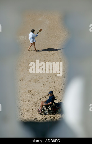 Man in wheelchair on Benidorm beach Stock Photo