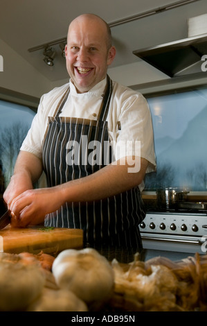 Smiling chef chopping ingredients Stock Photo