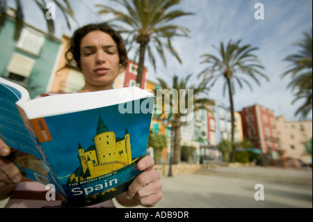 Female tourist reading Spanish guidebook Stock Photo