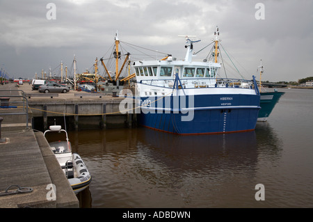 fishing boats moored in wexford town harbour quay with storm thunderclouds approaching Stock Photo