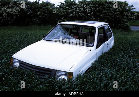 Abandoned car in a field after a crash on a country road in Suffolk, UK. Stock Photo