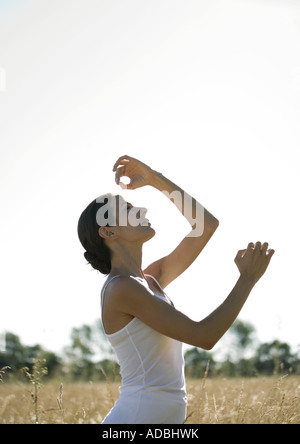 Woman doing yoga pose in field Stock Photo