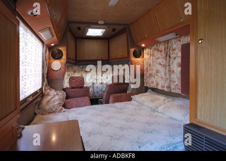 Interior furnishings seating converted to bed in two birth coach built VW RV Volkswagen Auto Sleeper camper van view to cab curtains duvet pillows UK Stock Photo