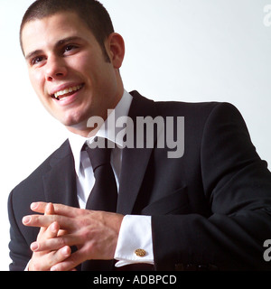 Businessman clasping hands and smiling, studio shot Stock Photo