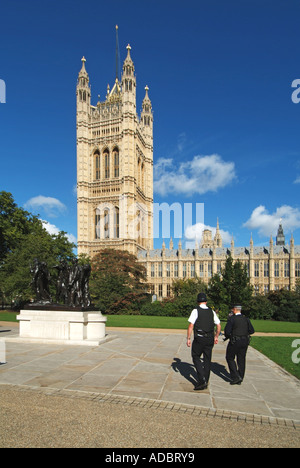 Victoria Gardens armed police patrol park adjacent to House of Lords and Houses of Parliament & Burghers of Calais sculpture Stock Photo