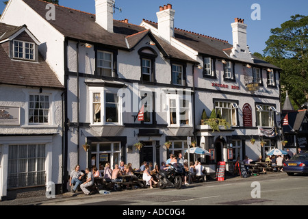 People drinking outside a public house on pavement in summer Llangollen Wales UK Stock Photo