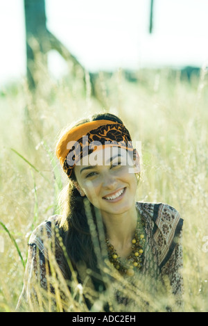 Young woman wearing scarf around head, in field, portrait Stock Photo