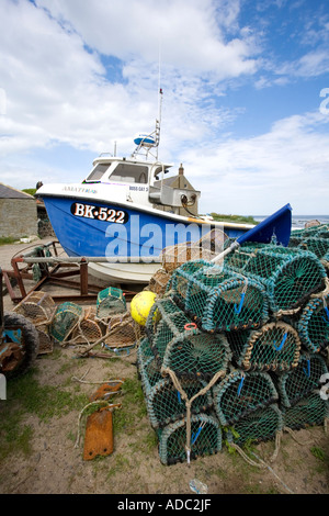 Crab pots and fishing boat Boulmer Northumberland Stock Photo