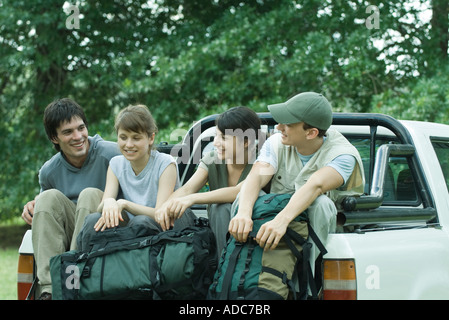 Group of hikers sitting in back of pick-up truck Stock Photo