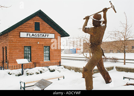 Gandy Dancer bronze sculpture wears winter snow in downtown Flagstaff Arizona Stock Photo