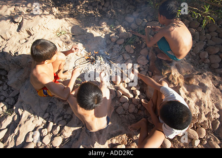 Boys Cooking Fish On Fire Stock Photo