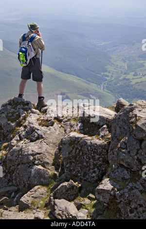 Climber on Penygadair , the summit of Cadair Idris near Dolgellau Gwynedd Wales looking towards the Tallylyn Valley Stock Photo