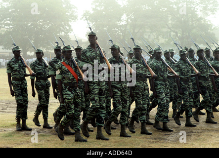 Tallest soldier among others carrying rifles marching in Independence Day parade Banjul Gambia Stock Photo