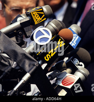Microphones from media outlets are bundled to a stand during an outdoor press conference Stock Photo
