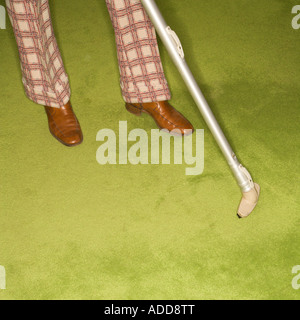 Close up of Caucasian male feet with vacuum extension against green retro carpet Stock Photo