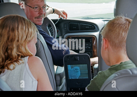 Kids Watch TV in Back of Minivan Stock Photo