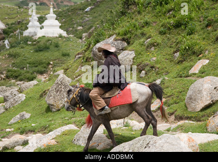 A Khampa horseman on his mount at Dzogchen in the Tibetan region of northwest Sichuan China Stock Photo