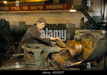 Miner working oiling a lathe in the engineering workshop at the Sots Donbs mine, Donetske, Ukraine. Stock Photo