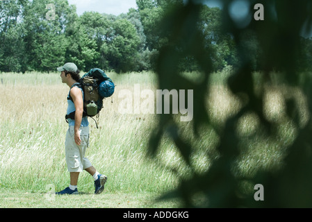 Hiker walking through field Stock Photo