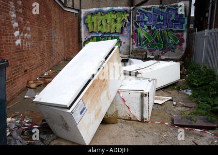 Abandoned fridges and freezers in a back alley behind a parade of shops Stock Photo