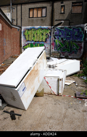 Abandoned fridges and freezers in a back alley behind a parade of shops Stock Photo