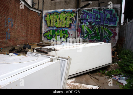 Abandoned fridges and freezers in a back alley behind a parade of shops Stock Photo