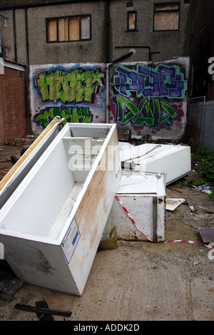 Abandoned fridges and freezers in a back alley behind a parade of shops Stock Photo