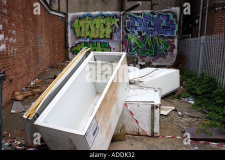 Abandoned fridges and freezers in a back alley behind a parade of shops Stock Photo