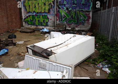 Abandoned fridges and freezers in a back alley behind a parade of shops Stock Photo