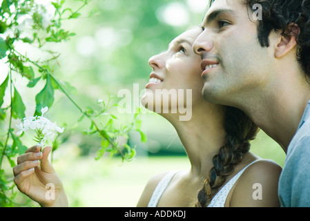 Couple looking at flowering plant together Stock Photo