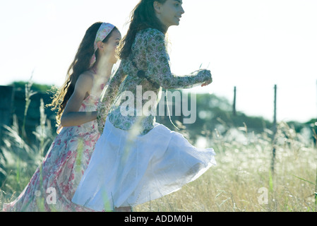 Young hippie women running in field Stock Photo