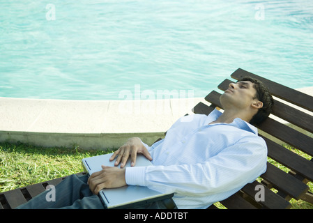 Businessman reclining on lounge chair Stock Photo