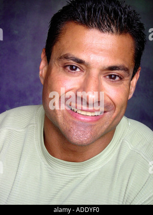 Head and Shoulders Portrait Head Shot of a Man of Latin Hispanic Heritage Wearing a Pastel Green Knit Shirt Stock Photo