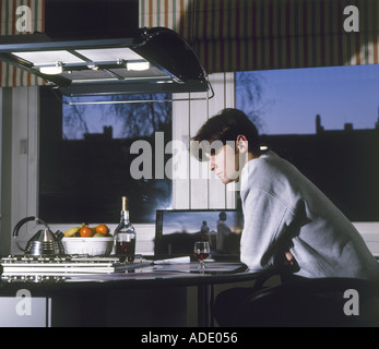 Young man having dinner at home near the window Stock Photo