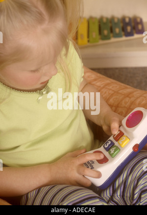 Young girl playing with plastic toy telephone Stock Photo