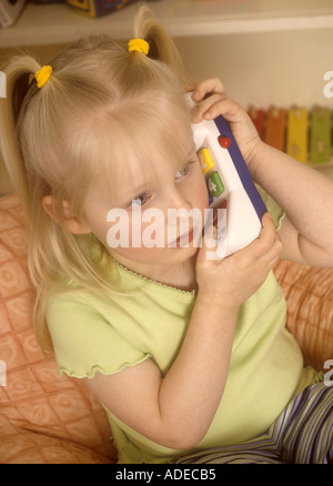 Young girl playing with plastic toy telephone Stock Photo