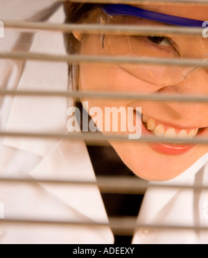 Researcher/scientist looking through metal shelving grid. Stock Photo