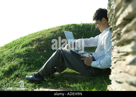 Businessman sitting outdoors, using laptop Stock Photo