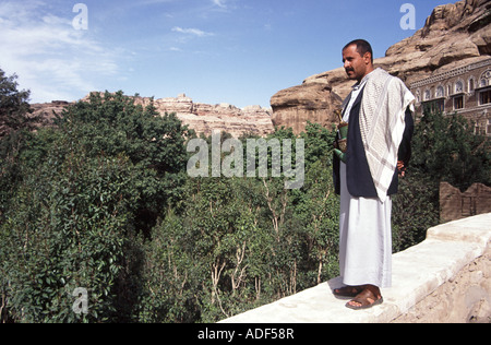 Local guide on roof of Dar Al Hajar Palace, overlooking qat tree plantation, Wadi Dahr, Yemen Stock Photo