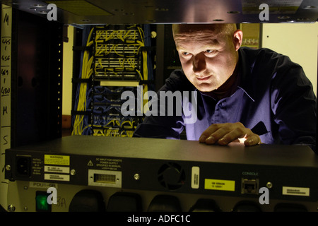 Specialist network engineer checking switching and cabling at telecoms business in Cardiff South Wales UK Stock Photo