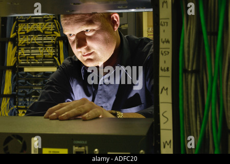 Specialist network engineer checking switching and cabling at telecoms business in Cardiff South Wales UK Stock Photo