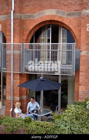 A LAPTOP BEING USED BY A COUPLE ON A PATIO AREA OF A CONTEMPORARY STUDIO FLAT UK 2007 Stock Photo