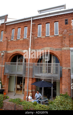 A LAPTOP BEING USED BY A COUPLE ON A PATIO AREA OF A CONTEMPORARY STUDIO FLAT UK 2007 Stock Photo