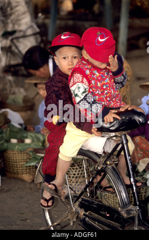 Two Burmese children  riding on a bike Stock Photo