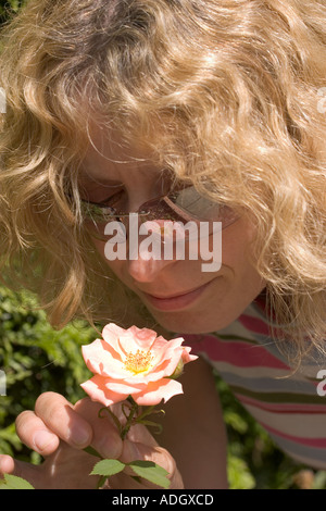 Young woman smelling a rose Stock Photo - Alamy
